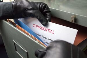 Thief taking Confidential Document from filing cabinet